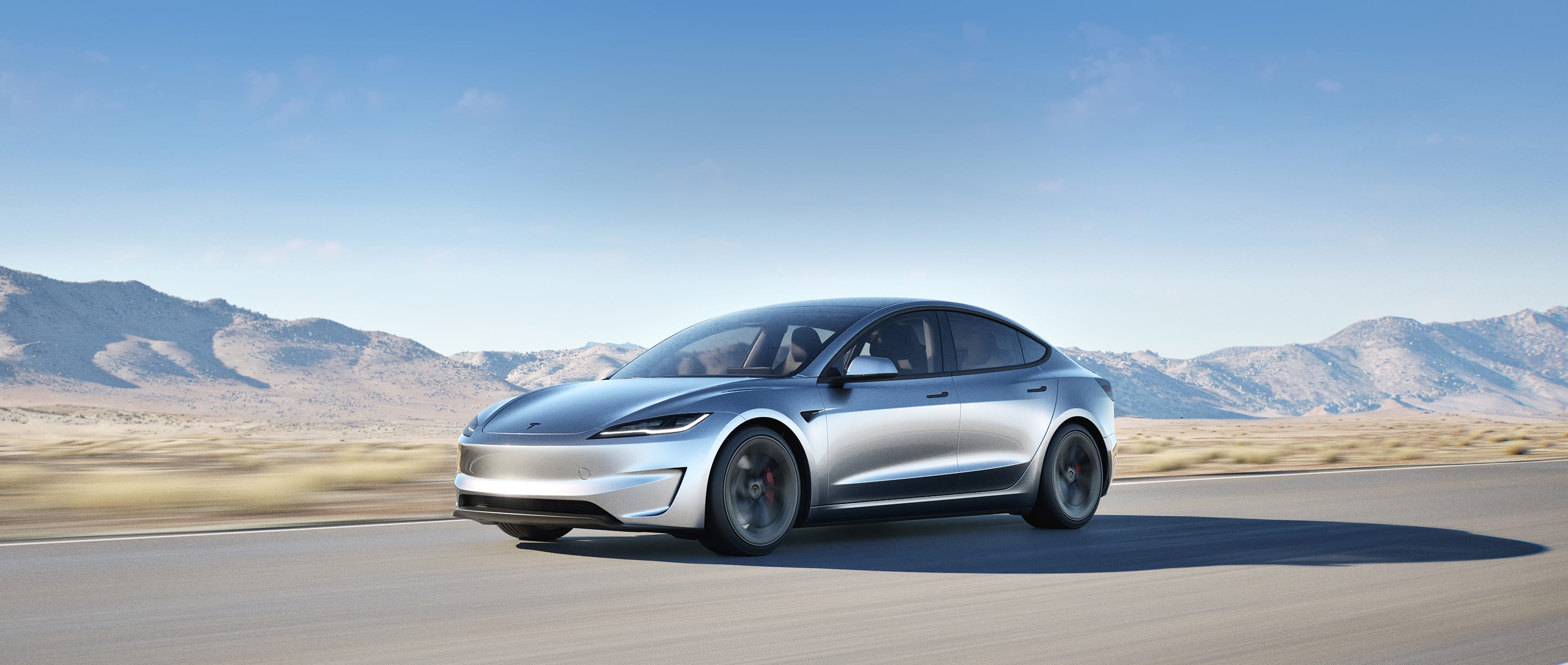 Silver Model 3 driving through the desert
